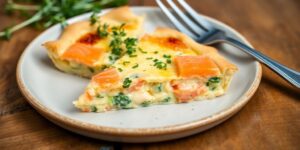 Eine köstliche Fenchel-Lachs-Quiche auf einem Holztablett.