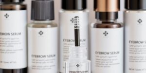 Flaschen mit Augenbrauenserum auf einem sauberen Hintergrund.