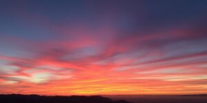 Sonnenuntergang über malerischer Landschaft mit warmen Farben.