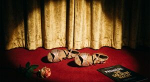 Tanzschuhe auf rotem Teppich vor goldglänzendem Vorhang – Glamour trifft Bühne