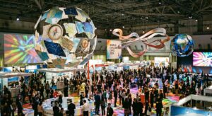 Bunte Darstellung einer Reisemesse mit Symbolen der Erkundung