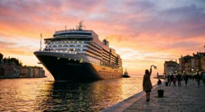 Kreuzfahrtschiff verlässt den Hafen bei Sonnenuntergang, Person winkt vom Pier aus