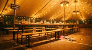 Leere Bierbank mit Maßkrügen in warmem Licht ohne Personen – symbolisch für HeidiFest-Verspätungen